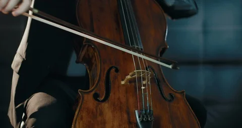 A man in a suit playing a cello in a dark room Stock Footage 87224584