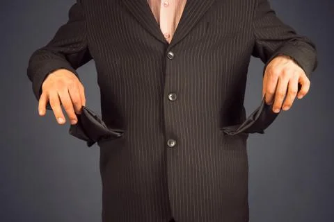 Man in a suit with pockets turned inside out. concept of crisis Stock Photos