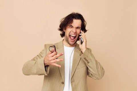 Man in a suit posing emotions talking on the phone Lifestyle unaltered Stock Photos