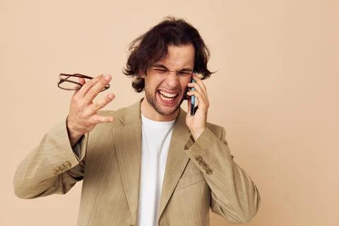 Man in a suit posing emotions talking on the phone Lifestyle unaltered Stock Photos