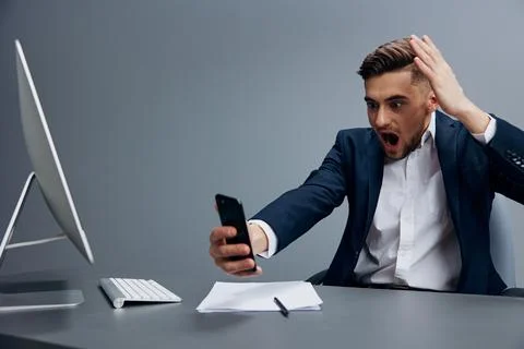 A man in a suit problems at work sitting at a desk in front of a computer Stock Photos