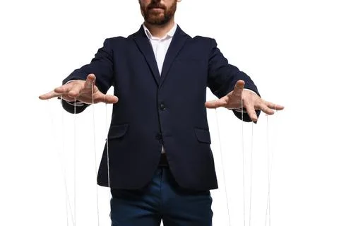 Man in suit pulling strings of puppet on white background, closeup Foto stock