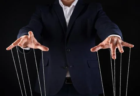 Man in suit pulling strings of puppet on black background, closeup Stock Photos