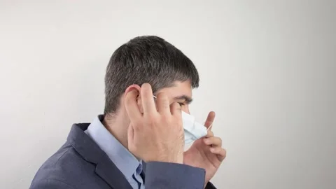 Man in a suit putting on a mask Stock Footage 169725832