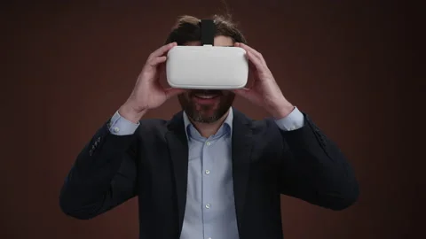 A man in a suit puttion on his vr headset with a happiness on his face Stock Footage 238074081