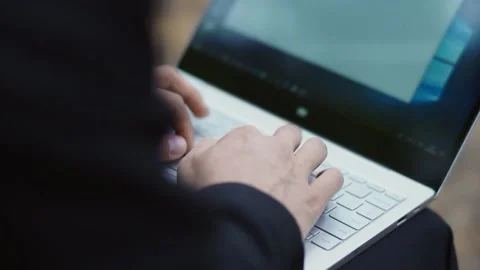 A man in a suit quickly prints a message on a laptop Stock Footage 147328975