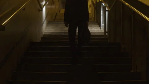 A man in a suit with rabbit mask going up the stairs 库存影片 259654235