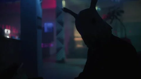 A man in a suit with rabbit mask playing a piano at the club and looking at.. Stock-Footage 259039191