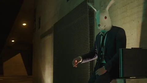 A man in a suit with rabbit mask pointing at something Vídeo Stock 259648879