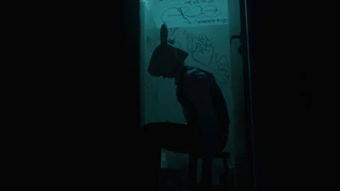 A man in a suit with rabbit mask sitting alone in the bathroom looking sad Stock Footage 259013532