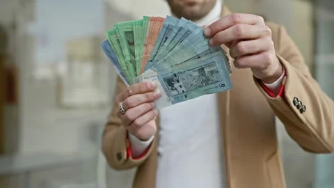 Man in suit showing malaysian ringgit on urban street Stock Footage 264912292