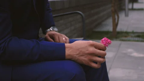 A man in a suit sits on a bench and waits Stock Footage 95914155