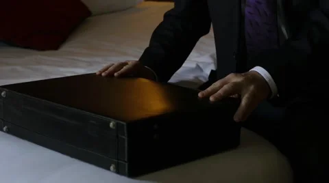 Man in Suit Sits Down on Hotel Room Bed and Opens Briefcase Stock Footage