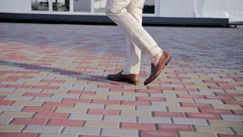 A man in a suit slowly walks down the sidewalk. Men's shoes (slow motion) Stock Footage 221628298