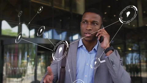 Man in suit speaking on phone while lightbulb node appearing near hand and Stock Footage 332981485