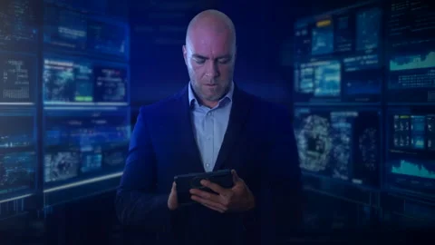 A man in a suit is standing in front of multiple digital screens Stock Footage 284697325