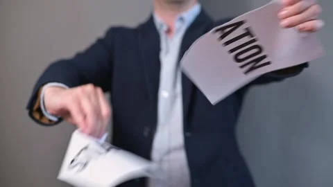 A man in a suit stands against a plain backdrop and demonstrates a motivational Stock-Footage 338299664