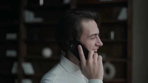 Man in a suit talking on the phone by the window Stock Footage 168647694