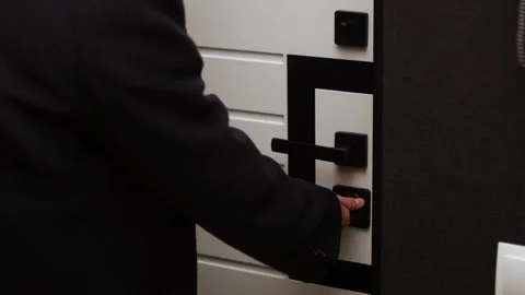Man in suit turning a key in a modern door lock mechanism Stock Footage 339070860