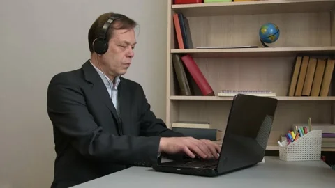 A man in a suit is typing on a laptop while sitting at home. Concept: remote wor Stock Footage 219332696