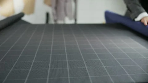 Man in a Suit Unrolling a Blue Piece of Material Stock Footage 89729897