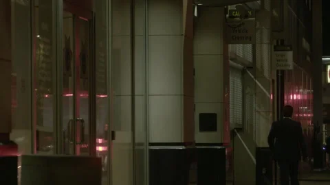 Man in Suit Walking Along Downtown Sidewalk at Night Stock Footage 344610070
