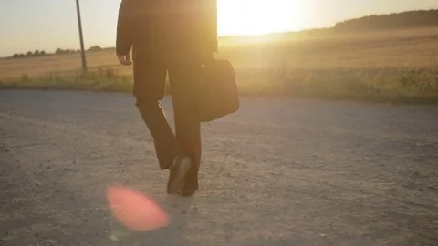 Man in suit walking along the road Stock Footage 71925761
