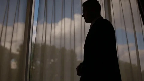 Man in suit walking in front of the big window Stock Footage 81719006