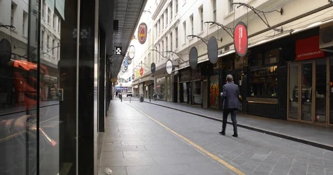 Man in Suit Walks Down Empty Restaurant District During COVID Shutdown Video stock 129349586
