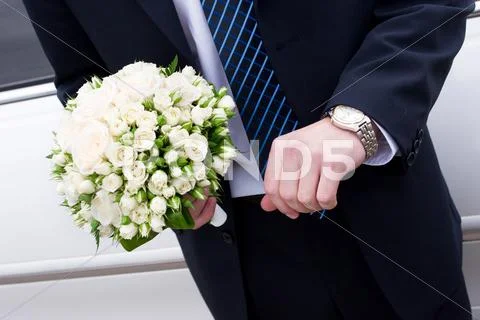 A Man In Suit With Watch Hands A Flower Bouquet