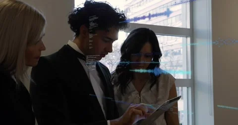 Man in suit by window swiping tablet, projecting holograms and code while team Stock Footage 334033917
