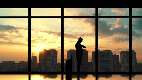 The man with suitcase stands indoors on the big buildings background Stock Footage 140103496