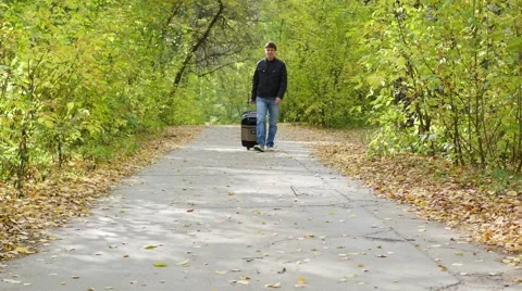Man with suitcase walking on pavement Vídeo Stock 68142865