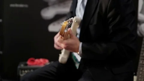 The man in a suite playing the guitar Stock Footage 81457575
