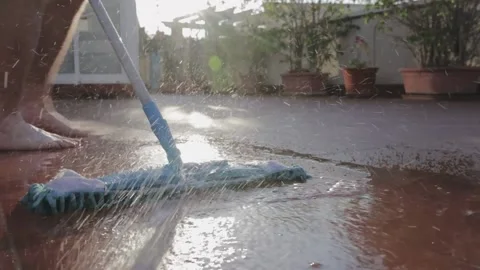 Man in the summer in the backyard mop washes the patio  Stock Footage 147173688