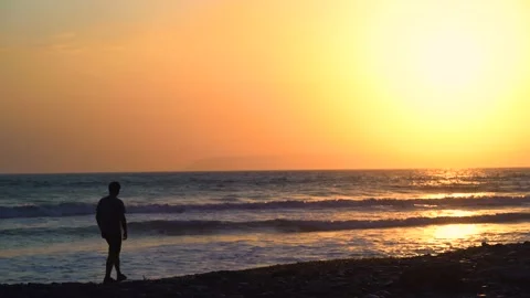 Man on summer holidays walking on beach at sunset Stock-Footage 133376127