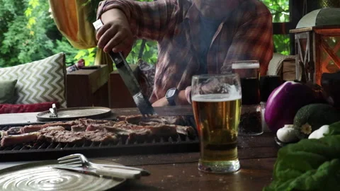 Man in the summer kitchen grilling meat Stock Footage 280189661