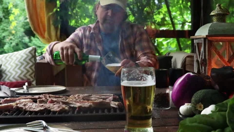 Man in the summer kitchen grilling meat Stock Footage 280189842