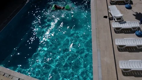 Man Sunbathing and Having Fun on a Floating Mattress on a Sparkling Swimming Stock Footage 71186786