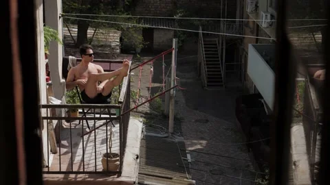 Man sunbathing on the balcony Stock Footage 194400152