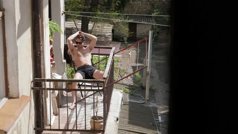 Man sunbathing on the balcony Stock Footage 194741649