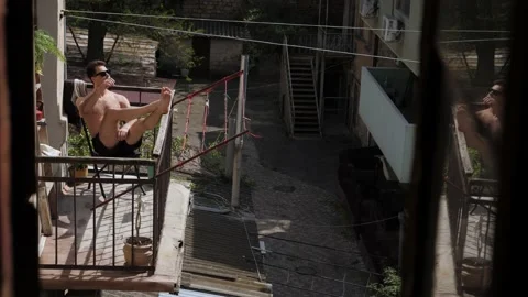 Man sunbathing on the balcony Video stock 195052120