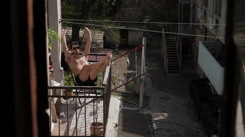 Man sunbathing on the balcony Stock Footage 195339320