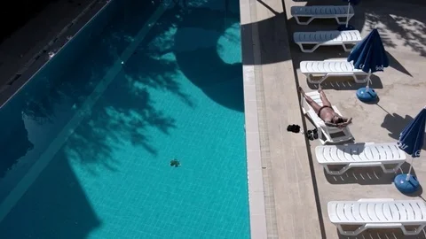 Man Sunbathing on Sunbed by the Pool Time Lapse From Above Stock Footage 71186692