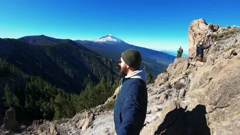 Man in sunglasses with beard climbed to top of mountain. Enjoys beautiful view Видео 156791606