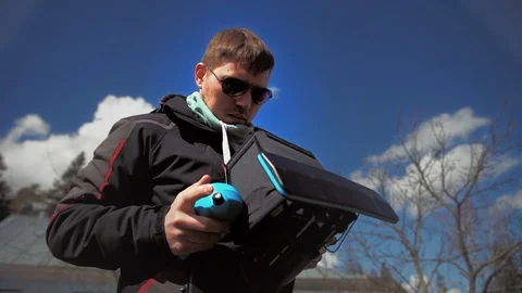 Man in sunglasses controls the drone and looks at it Stock Footage 97410670