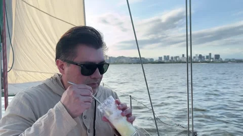 Man with sunglasses drinking refreshing beverage on boat in Rio de Janeiro .. 库存影片 331310435