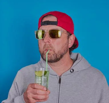 Man in sunglasses having a cold drink. Stock Photos