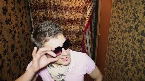 Man in sunglasses, scarf sing in camera and dance in corridor. Parody. Fun Vidéo 75314809