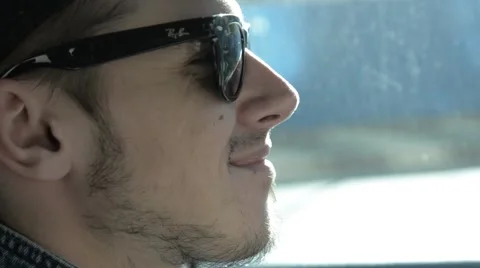 A man in sunglasses smiling sitting behind the wheel. Stock Footage 51756524